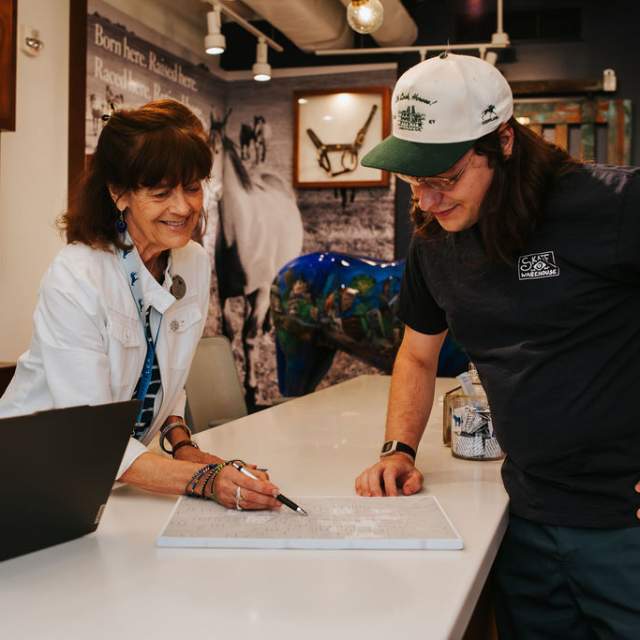 A visitor information specialist assisting a visitor at the counter