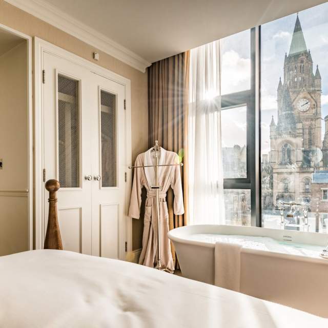 Hotel bedroom with bathtub and view to Manchester Town Hall