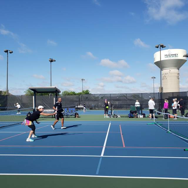 People on the tennis courts at The Courts Tennis Center