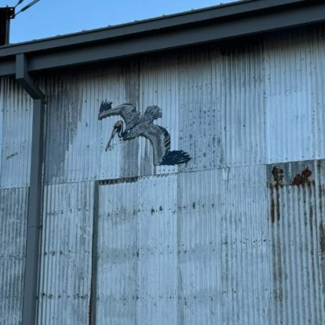Metal building with a life sized bird painted on it