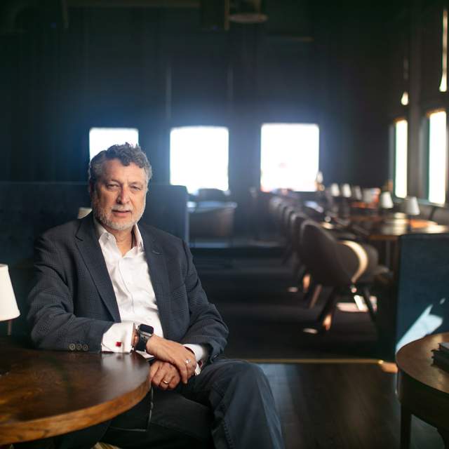man sitting at a table in a quiet intimate restaurant setting - sunlight coming through windows