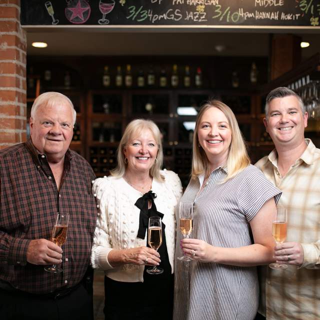 Older couple and younger couple holding wine glasses
