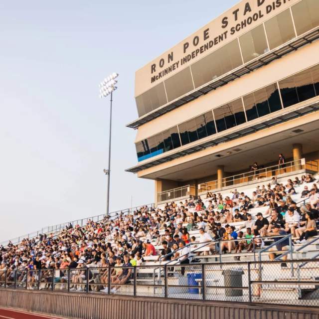 Fans in a stadium cheering on a soccer game