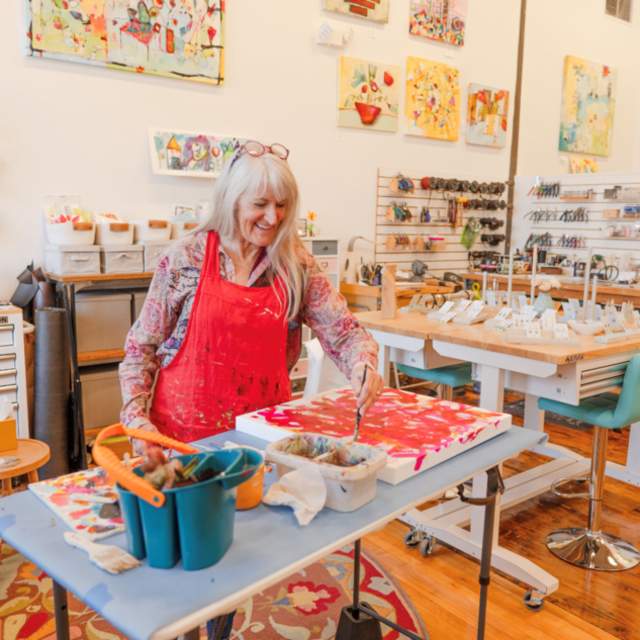 Woman standing with a red apron on painting