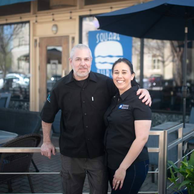 Square Burger  - Man and woman owners in front of restaurant