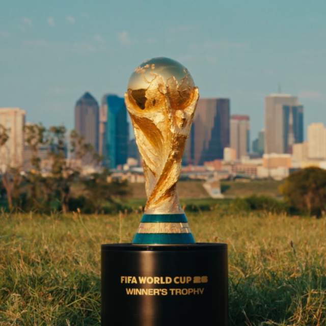 Gold trophy with a globe on top of a curved arm