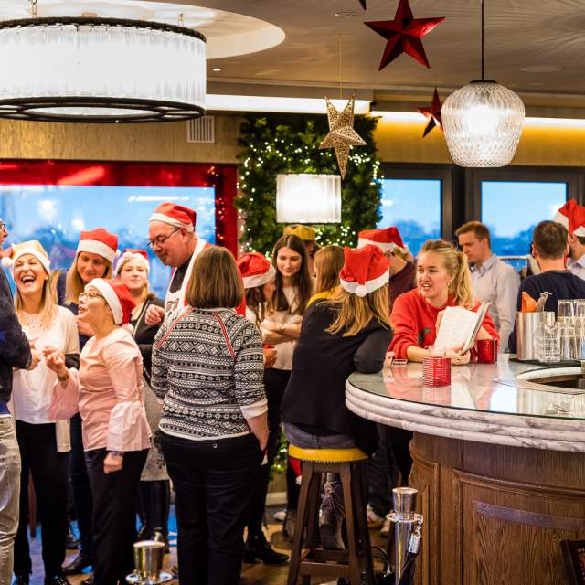 The Varsity Hotel - SIX Brasserie at Christmas with many people talking and laughing in Santa style hats