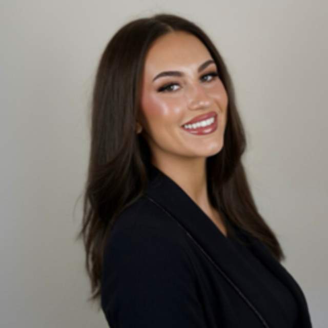 Abi Hammonds headshot smiling at camera wearing black blazer