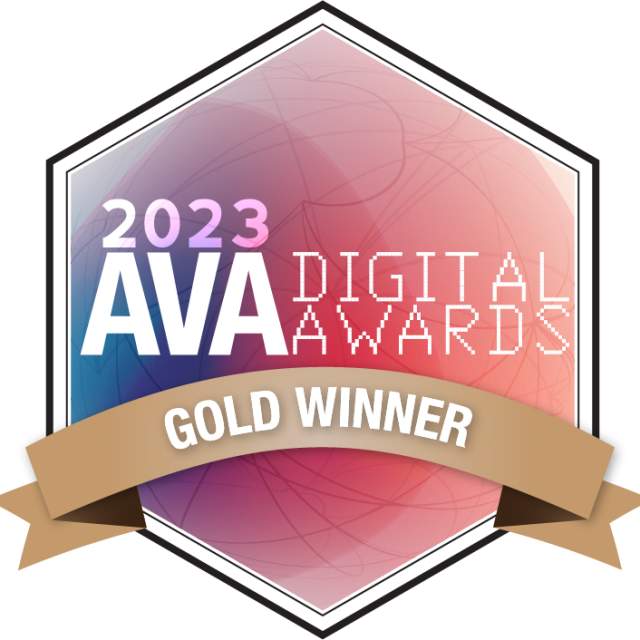 2023 AVA Digital Awards Gold Winner badge featuring a hexagonal design with a pink-to-blue gradient background, white text reading ‘AVA Digital Awards,’ and a gold ribbon across the bottom labeled ‘Gold Winner.’
