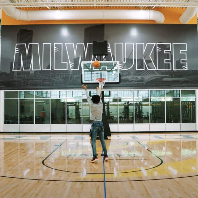 someone shooting a basketball in a Milwaukee Panther branded gym