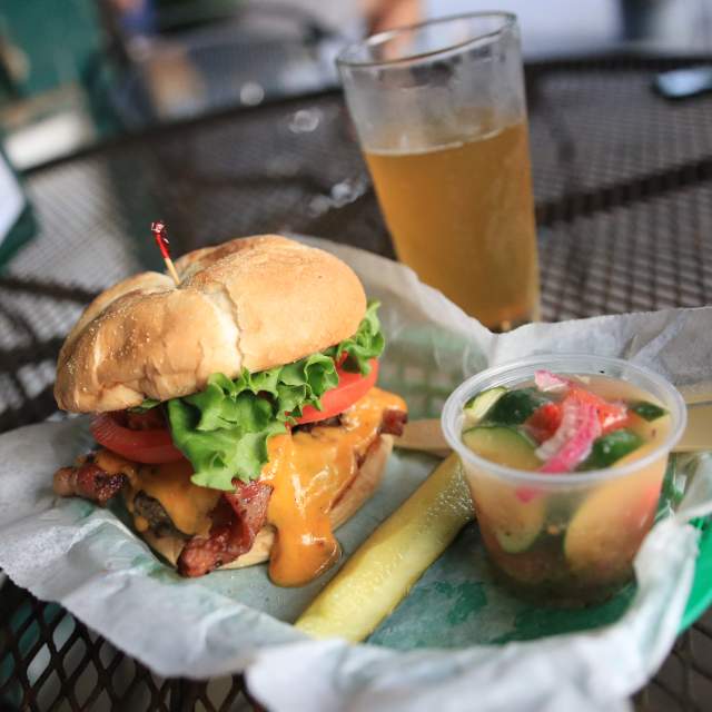 Bacon Cheeseburger, pickle spear, cup of tomato and cucumber salad
