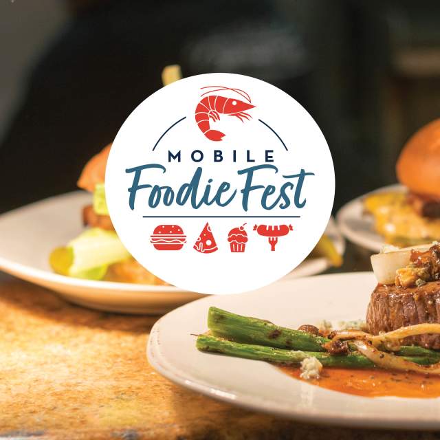 Mobile Foodie Fest logo (white circle with blue text and red icons of a shrimp, a burger, a pizza slice, a cupcake and a sausage on the end of a fork) with burgers and steak bites in the background