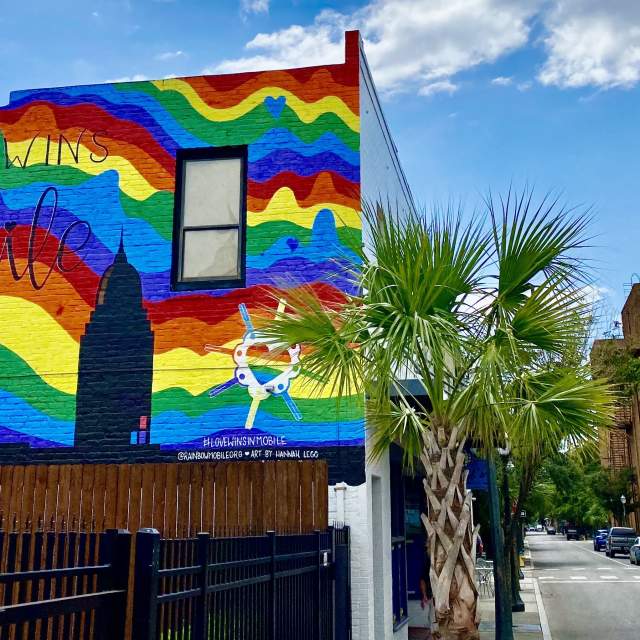 building with a mural of the city and a rainbow background