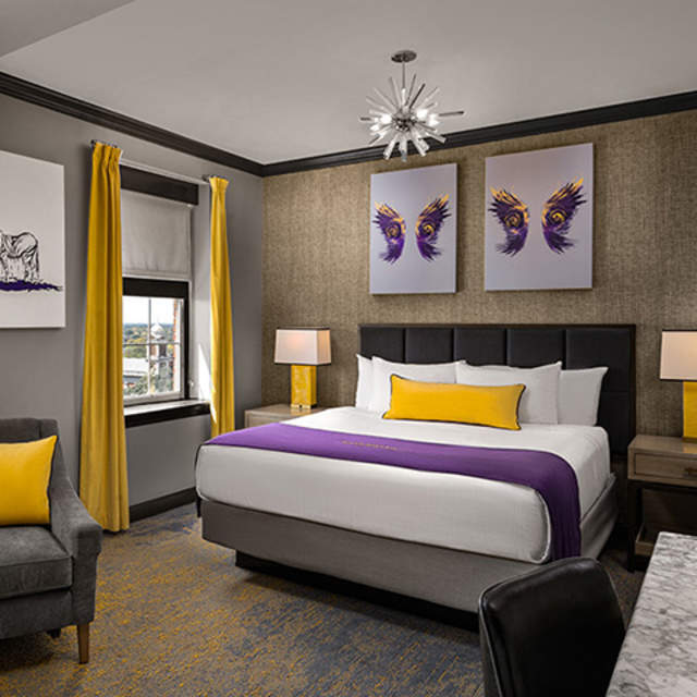 Hotel room bed, two framed artwork of wings above the bed