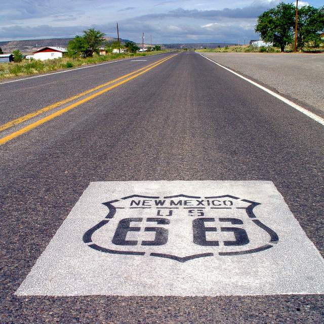 photo of a sign painted on asphalt reading New Mexico US 66 (route 66 highway)