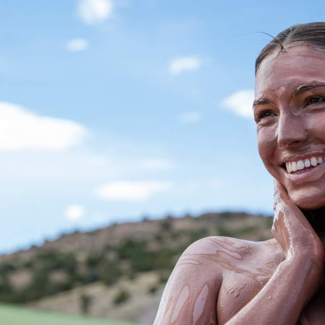A woman experiences a mud bath treatment at an area spa.