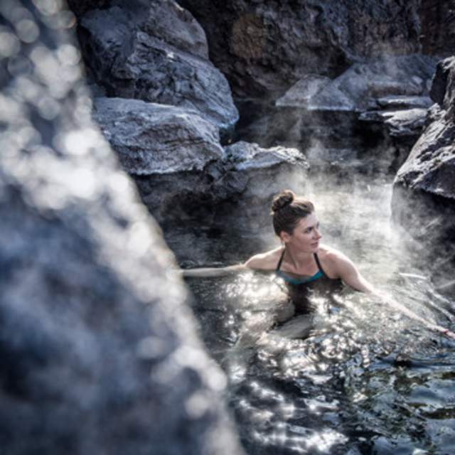 A woman relaxes in a naturally-occurring New Mexico how spring.