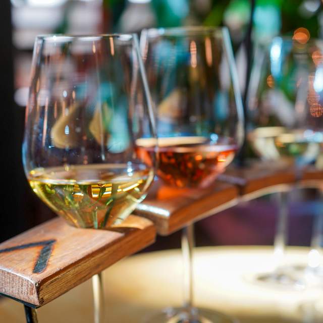 Different glasses of wine in a decorative wooden holder