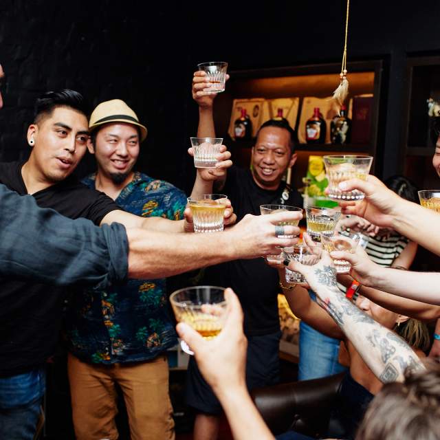 Several people clink glasses at Tales of the Cocktail event in 2023
