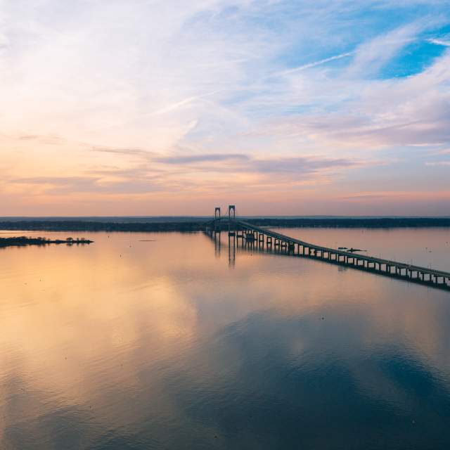 aerial view of a bridge over water at sunset