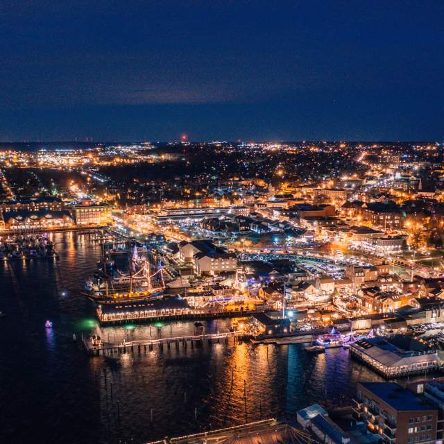 A nighttime aerial view of a city by the water.