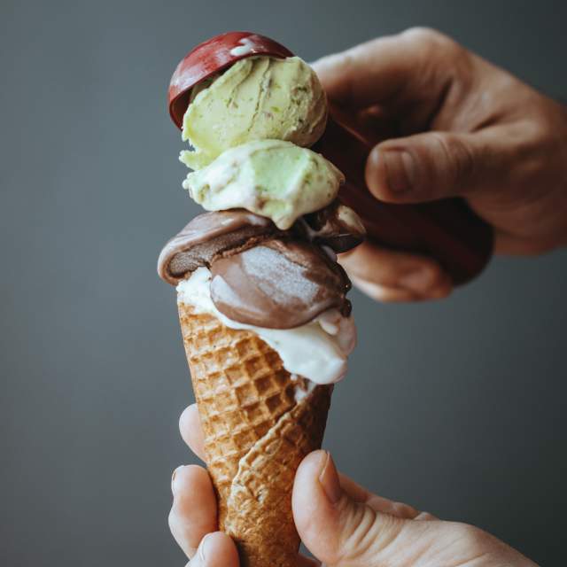 Stock ice cream photo of ice cream cone for Florida Dairy Farmer's Ice Cream Trail program. Chocolate milk and pistachios ice cream in a cornet, refreshing ice cream, Cocoa vanilla and pistachios flavor in ice cream, Delicious dessert or ice cream made from homemade ice cream, cornet and ice cream,human hand holding ice cream