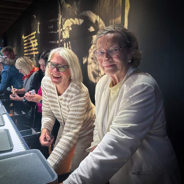 To glade damer prøver en installasjon på museet