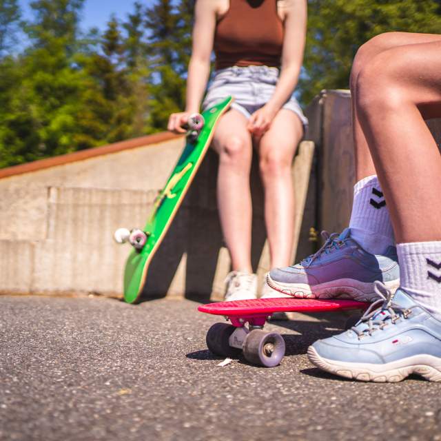 Nærbilde av 2 par føtter og 2 skateboard