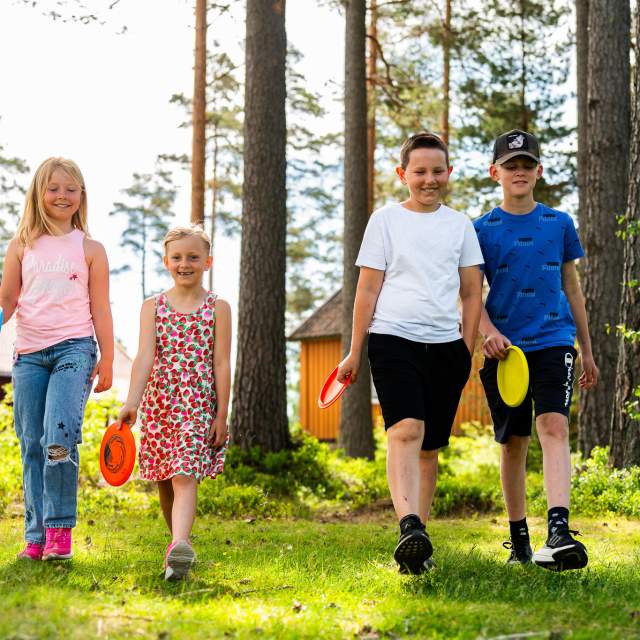Fire barn som kommer ruslende med hvert sitt frisbebrett