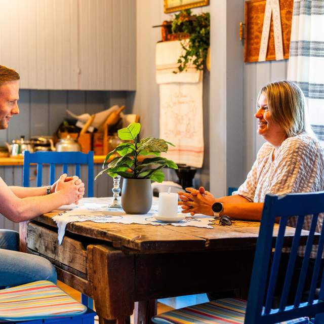 To som sitter rundt bordet på Skiptvet bygdetun på kjøkkenet