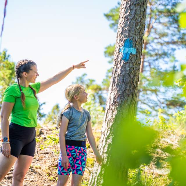 To barn følger blåløype i skogen i Ørje.