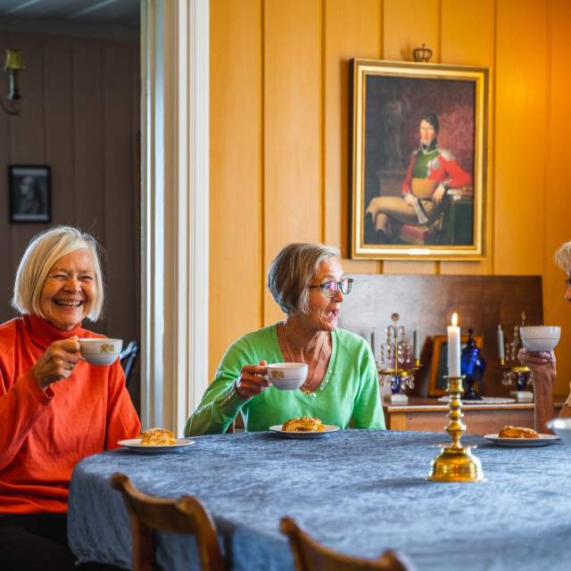Tre damer som koser seg med en kaffekopp inne på Spydeberg prestegård