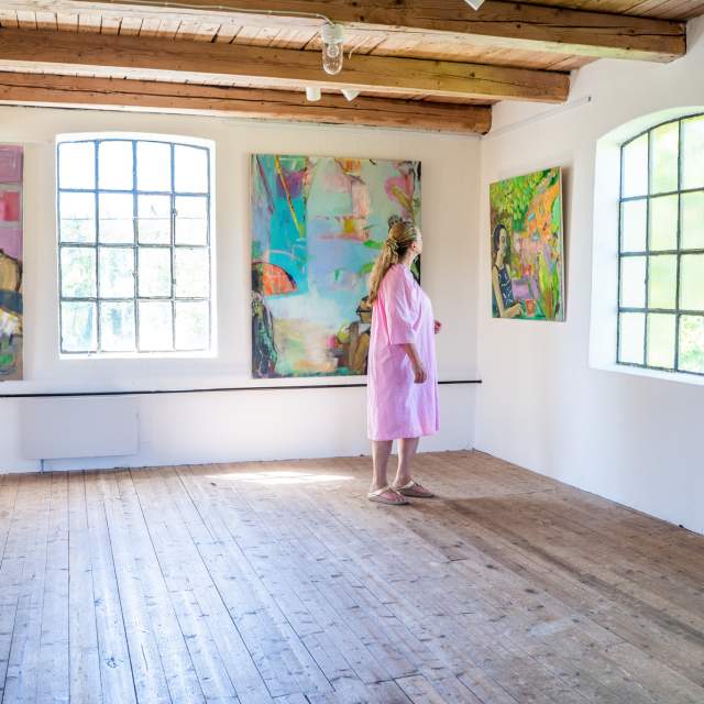 En dame kikker på bildene i galleri Strømsfoss