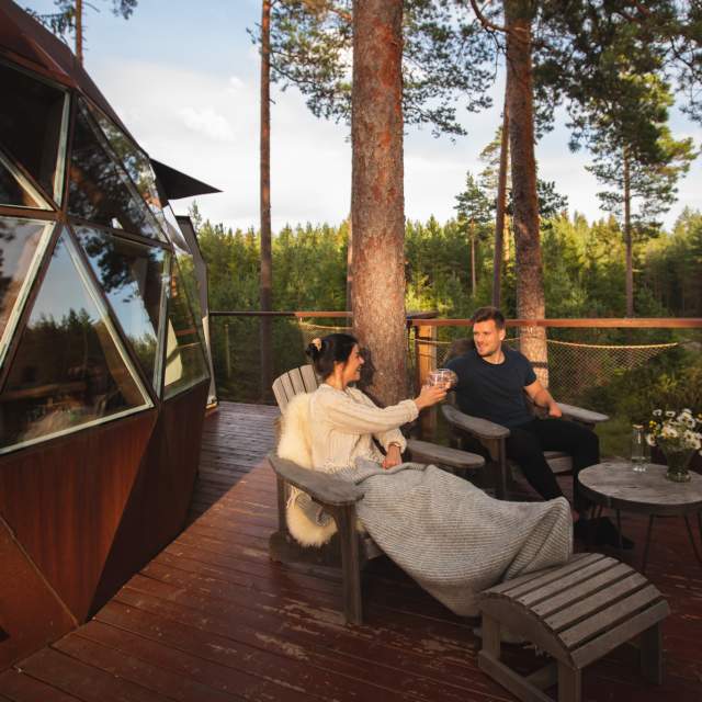 Ett par som hygger seg på terrassen til Tretoppdomen
