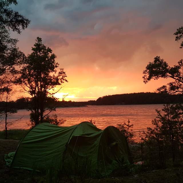 Telt i Vansjø med solnedgang