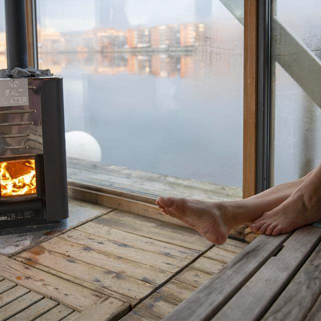 Kvinne slapper av ved ovnen i en fjordauna