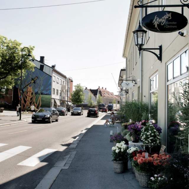 Bilde av sentrumsgata med biler og bygninger