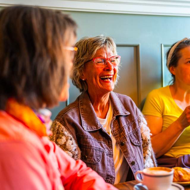 Damer med godt humør som koser seg på kafe i Spydeberg