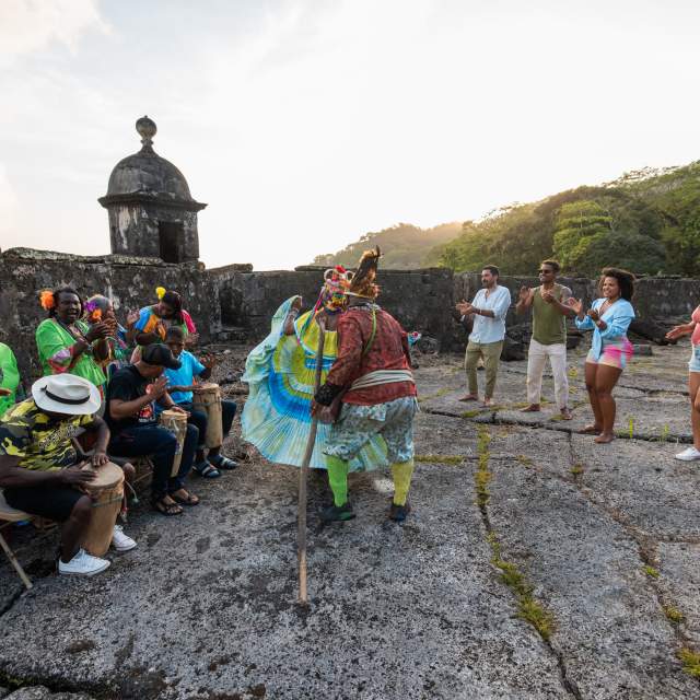 Group of Congos dancing wearing colorful polleras outside Fuerte San Fernando at Portobelo, Colon province