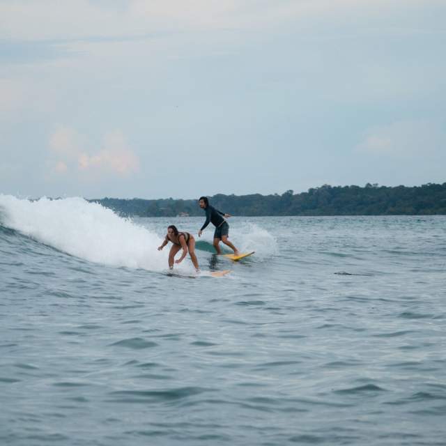 Surfers take a wave at Black Rock beach at Carenero Island