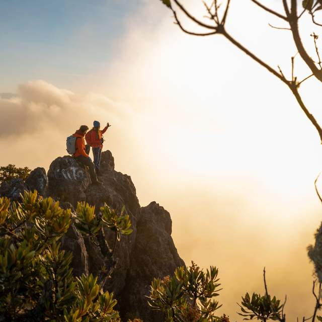 Casal no topo do Vulcão Barú ao pôr do sol, com vista panorâmica sobre um mar de nuvens. Em dias claros, deste ponto é possível ver o Oceano Pacífico e o Atlântico.