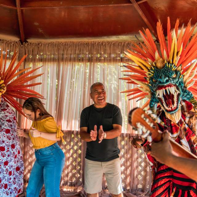Group of tourists share with locals dressed in devil costumes in La Villa de los Santos