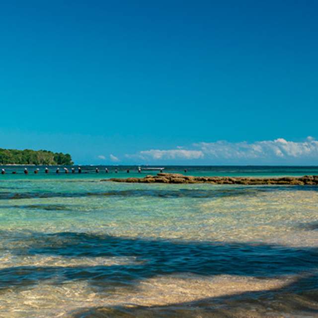 Dos mujeres caminando por la orilla, con equipo de snorkel en Bocas del Toro, Panamá