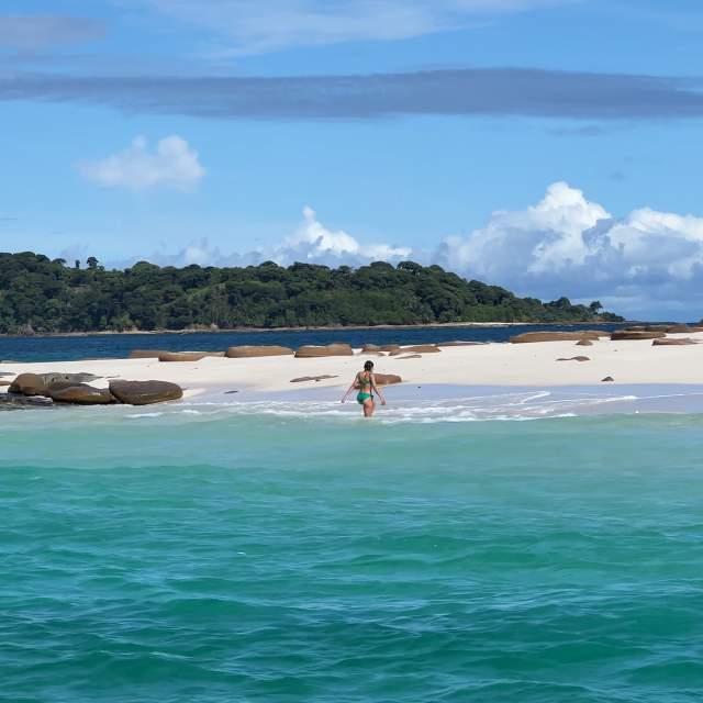 Woman walking along the beautiful sunny beach of Bartolome Island, Pearl Islands Panama City, Panamá