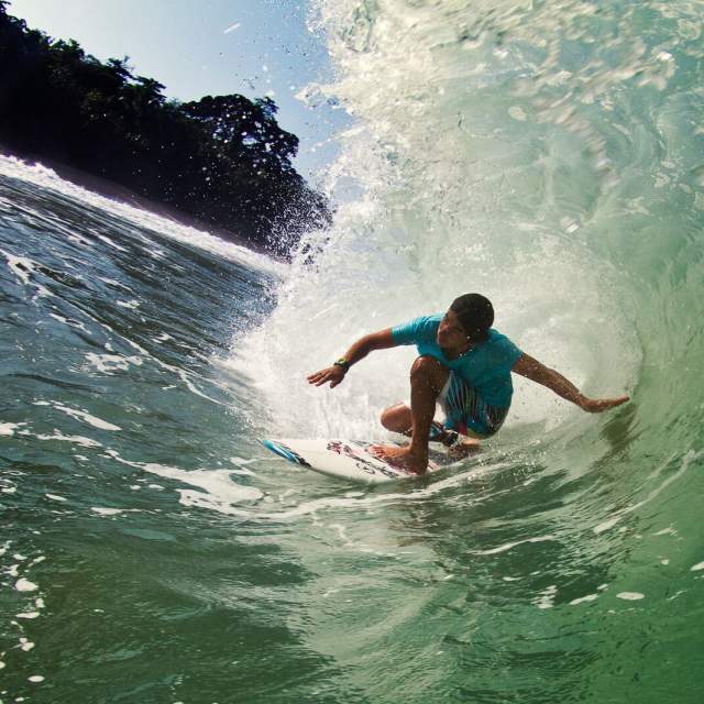 Surfer A surfer rides the perfect barrel in the pristine waters of Bluff Beach.