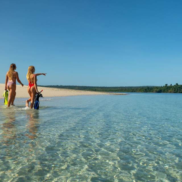 Two Women walking on the shore, with snorkeling gear