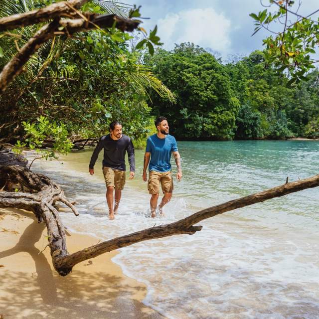 Two friends walking on a paradisiac Caribbean beach at Isla Colon, Bocas del Toro