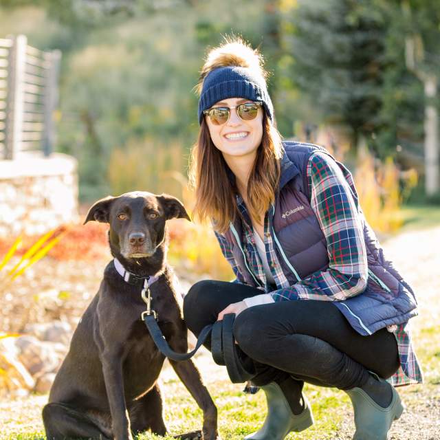 woman posing with dog in the fall
