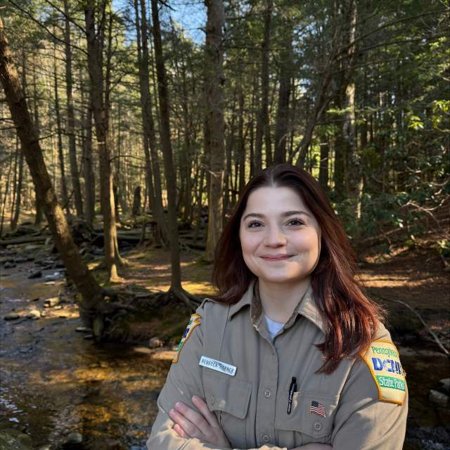 Woman posing for a photo in the woods