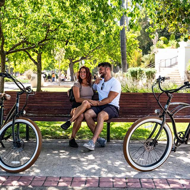 Two people sitting on bench in park